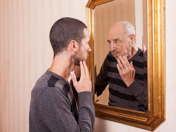young man looking at an older himself in the mirror young man looking at an older himself in the mirror